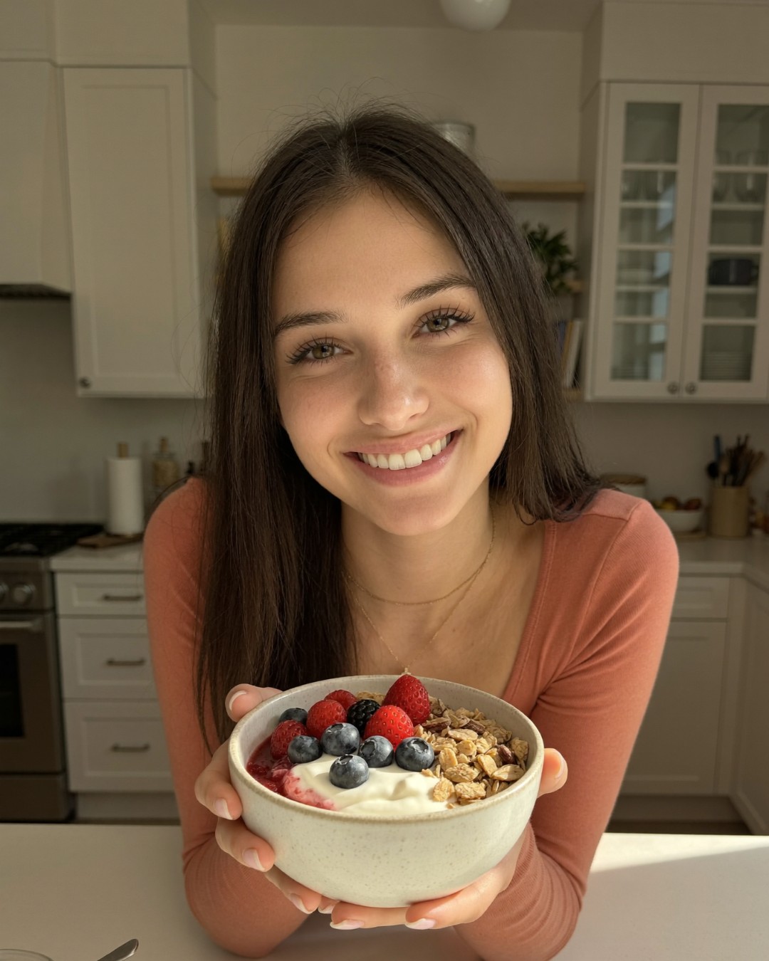 A woman holding a small bowl of Greek yogurt with berries